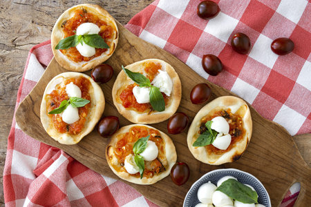 Homemade mini pizzas margarita with tomato, mozzarella and basil from above.Traditional Italian food