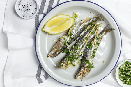 Homemade Grilled sardines with garlic, olive oil, fresh parsley and lemon.Healthy food concept