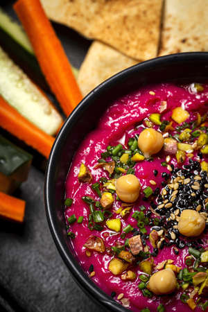 Homemade Beet and Chickpea Hummus with Vegetable CruditÃ©s and Unleavened Bread on Dark Backgroundの写真素材