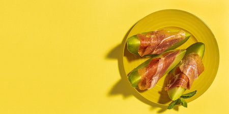 Sliced fresh melon with ham with sunlight on colorful backgrounds. Spanish food concept