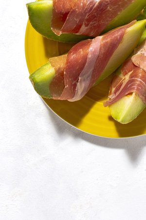 Sliced fresh melon with ham with sunlight on colorful backgrounds. Spanish food conceptの写真素材