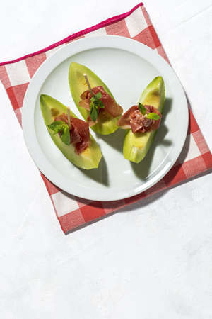 Sliced fresh melon with ham with sunlight on colorful backgrounds. Spanish food conceptの写真素材