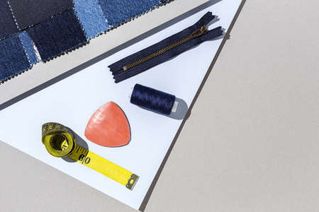 Handicraft, clothing repair. Ripped blue jeans sewing accessories with colorful background from above. Flat layの写真素材