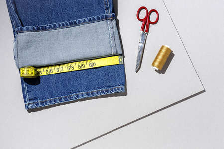 Handicraft, clothing repair. Ripped blue jeans sewing accessories with colorful background from above. Flat layの写真素材