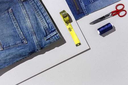 Handicraft, clothing repair. Ripped blue jeans sewing accessories with colorful background from above. Flat layの写真素材