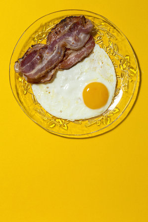 Homemade Fried egg with bacon. Traditional British breakfast in sunlight
