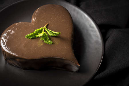 Homemade heart shaped chocolate cake on colors backgroundの写真素材