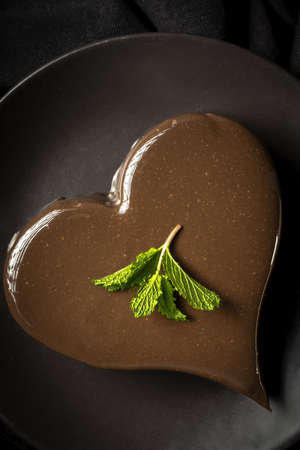 Homemade heart shaped chocolate cake on black backgroundの写真素材