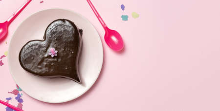 Homemade heart shaped chocolate cake on black backgroundの写真素材