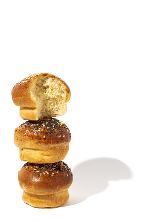 Assorted round homemade brioche buns with seeds on a white background with high contrast light. Isolatedの写真素材