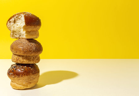 Assorted round homemade brioche buns with seeds on a colorful background with high contrast lightの写真素材