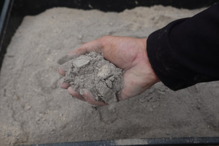 a handful of ashes to use in the garden. man holding a pile of wood ashesの写真素材