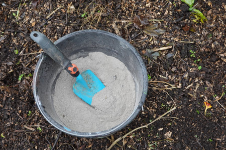 Shovel inside a bucket full of ash to use in the vegetable garden as fertilizer and insecticide.の写真素材