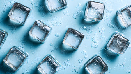 Ice cubes melting on a light blue background creating a refreshing summer pattern, ideal for backgrounds and designs to summer, coolness, and beveragesの素材