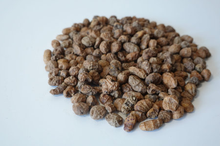 Tiger nuts, also known as chufa, forming a pile on a white background, representing healthy food and...