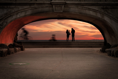 Beautiful small stone beach-side foot bridge in Australia with people walking in the background.の写真素材