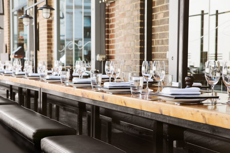 Empty glasses set in restaurant with long table
