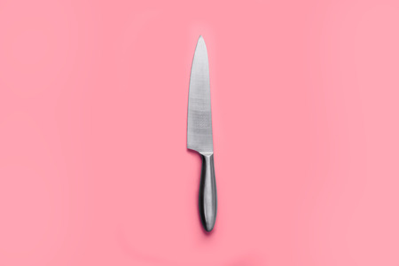 Stainless steel kitchen knife isolated over pink backgroundの写真素材
