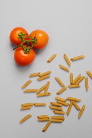 Raw pasta and fresh tomatos ingredients overhead viewの写真素材