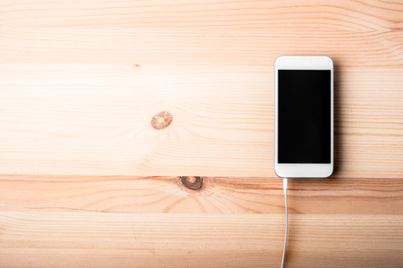 Blank smart phone on wood grain backgroundの写真素材