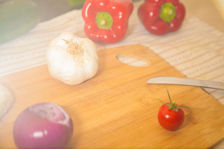 white garlic lies on a board with other vegetablesの写真素材