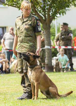 BURG / GERMANY - JUNE 25, 2016: german military police sheepdog sits by his owner on open day in barrack burg / germany at june 25, 2016のeditorial素材