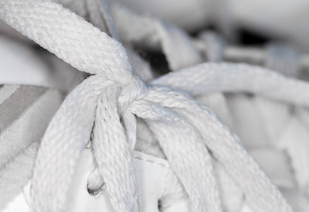 white shoelace knot on white gym shoesの写真素材