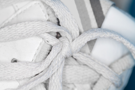 white shoelace knot on white gym shoesの写真素材