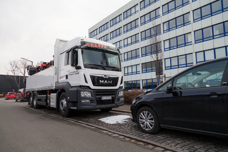 NUERNBERG / GERMANY - MARCH 4, 2018: MAN flatbed truck with crane stands on roadside in a industrial district.のeditorial素材