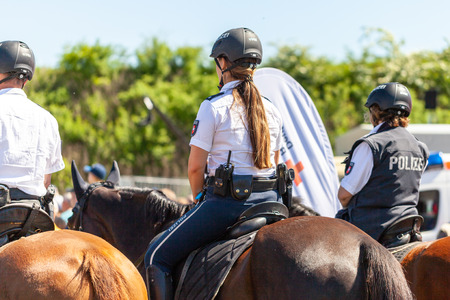 DELMENHORST / GERMANY - MAY 6, 2018: German police horsewoman rides on a police horse for training exercise in a crowd. The german word Polizei means police.のeditorial素材