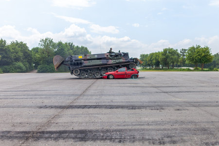 FELDKIRCHEN / GERMANY - JUNE 9, 2018: German tank dozer Dachs crashes a red car on day of the Bundeswehr in Feldkirchen.のeditorial素材