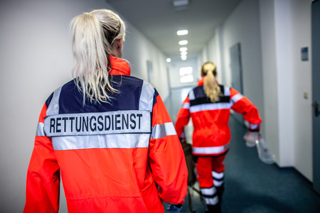 German paramedic runs in a floor to an accident. The german word RETTUNGSDIENST means emergency serviceの写真素材