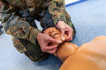 Paramedical soldier practices a medical training on a puppetの写真素材