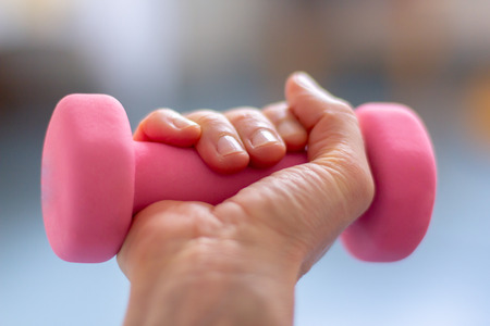 a woman  trains with pink dumb bellsの写真素材