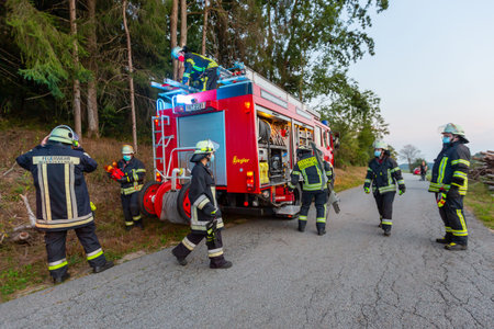 BAVARIA / GERMANY - SEPTEMBER 16, 2020: German firemen stands near a fire truck during an exercise