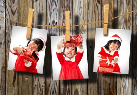 Photos of little girl wearing Santa Claus hat  hanging on wood wall.の写真素材