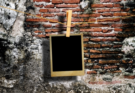 Old picture frame hanging on clothesline on grunge wall の写真素材