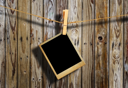 Old picture frame hanging on clothesline on grunge wall の写真素材