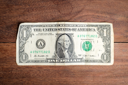One dollar on wood background.の写真素材