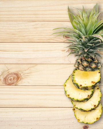 Pineapple with slices on wood background.の写真素材