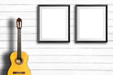 Classical guitar and blank picture frame in vintage wood room.の写真素材