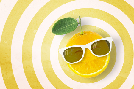 Smile orange wearing sunglasses on circle pattern yellow and white background with copy space.,Pastel tone.の写真素材