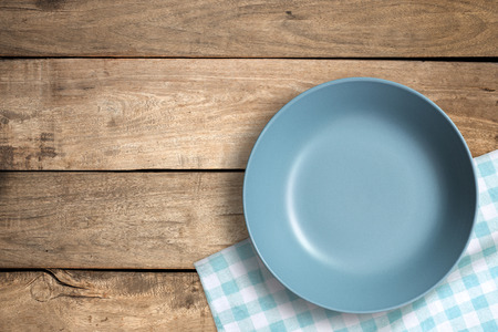 Top view of blank blue dish and blue tablecloth on a wood background with copy space.の写真素材
