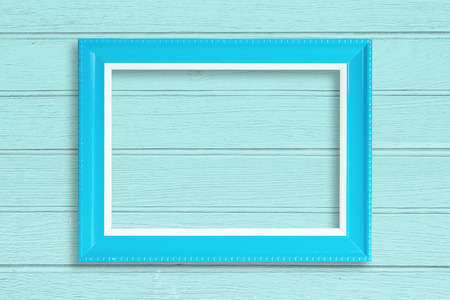 Blue blank picture frame on wood wall.の写真素材