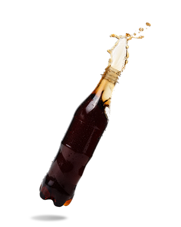 Soft drinks splash out of bottle on white background.の写真素材