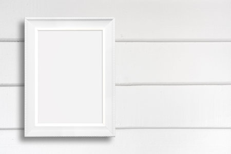 Old picture frame on white wood wall.