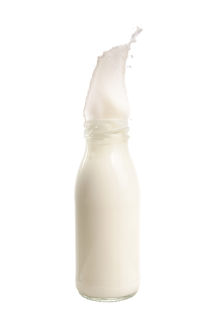 Milk splash out of bottle isolated on white background.の写真素材