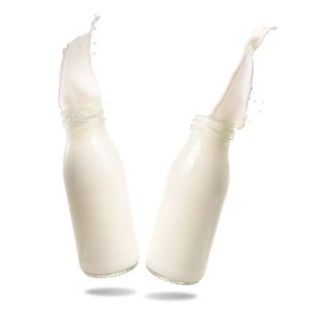 Milk splash out of bottle isolated on white background.の写真素材