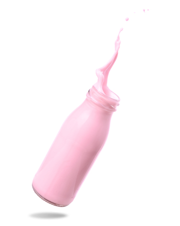 Strawberry milk splash out of bottle isolated on white background.の写真素材