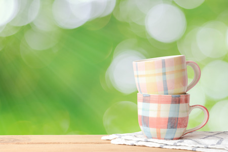 Coffee cup on wood table and green natural background., With copy space.の写真素材